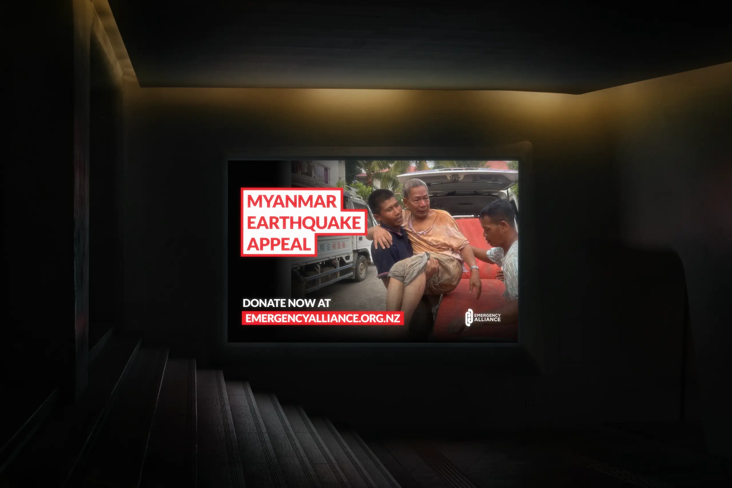 Screen showing a man injured in an earthquake being carried to help