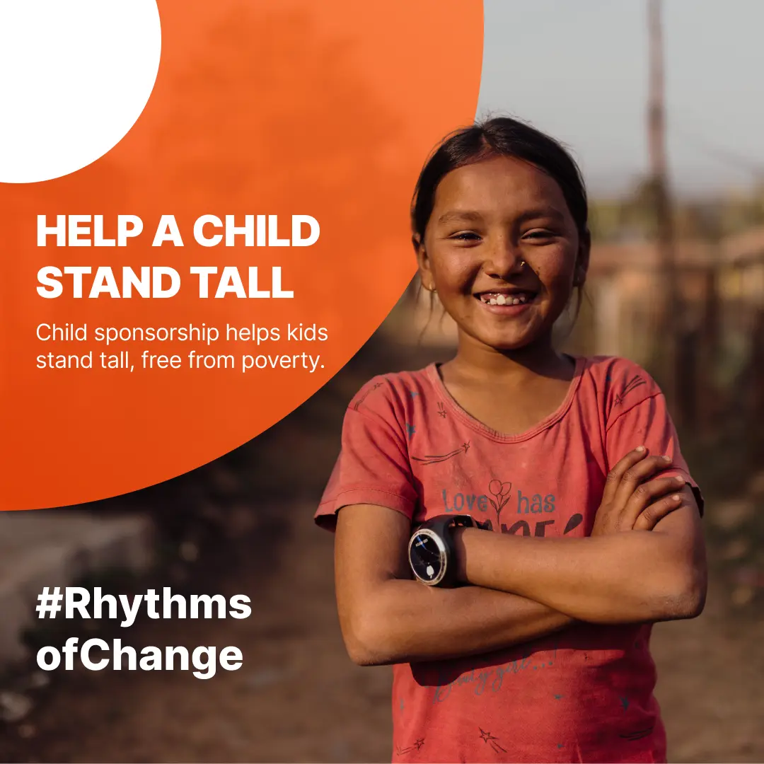 Girl in pink shirt with arms crossed smiling at camera