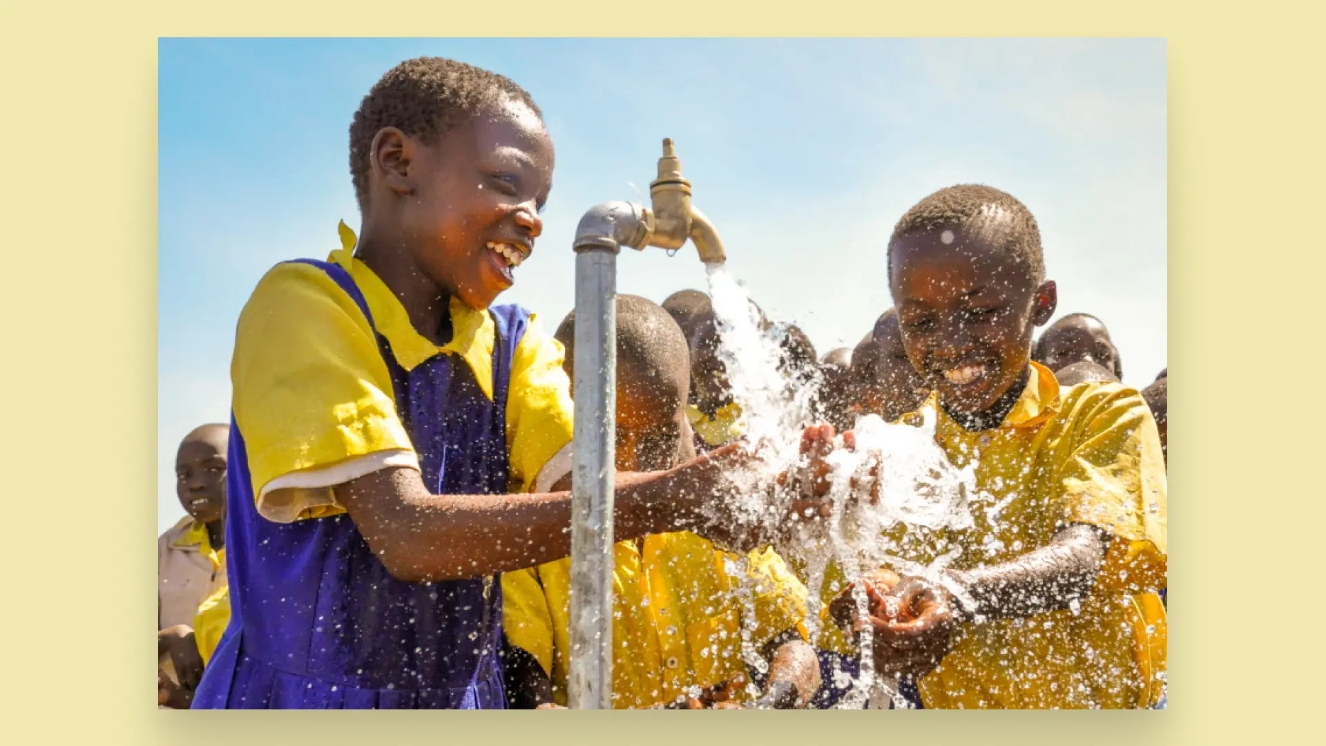 African kids laughing as they wash their hands in clean water